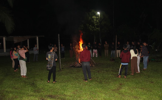 A group of people standing around a fireAI-generated content may be incorrect.